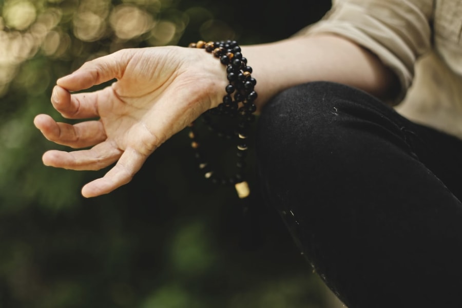 Main avec bracelet en bois pendant une séance de méditation